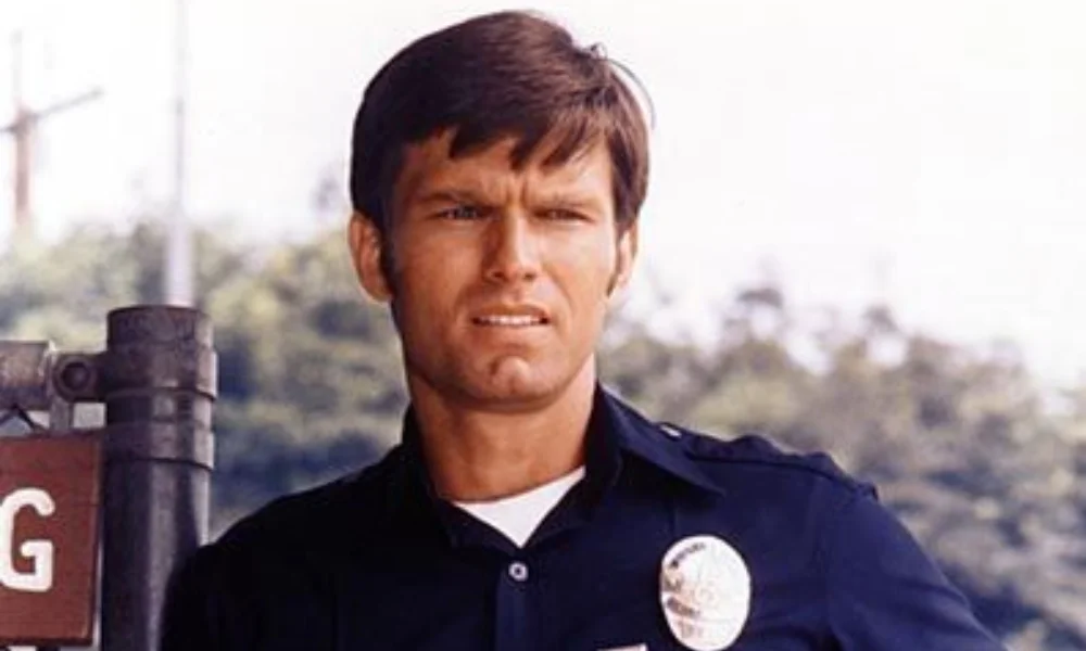 Young man wearing a police uniform stands outdoors-kent mccord net worth