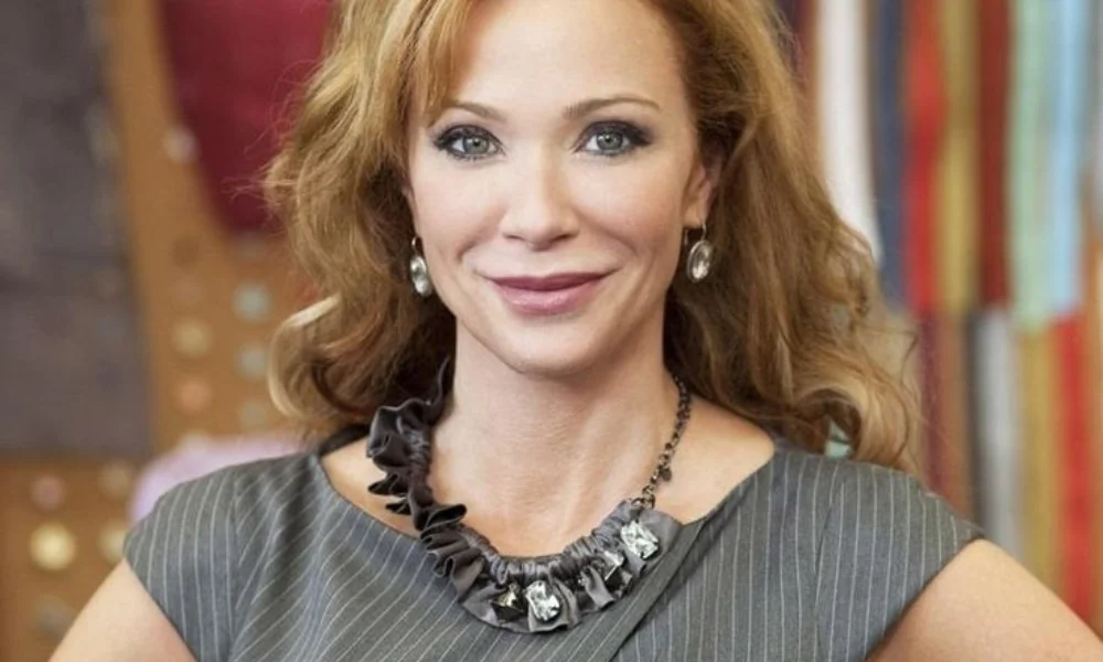 A woman with wavy, auburn hair smiles confidently-lauren holly's net worth