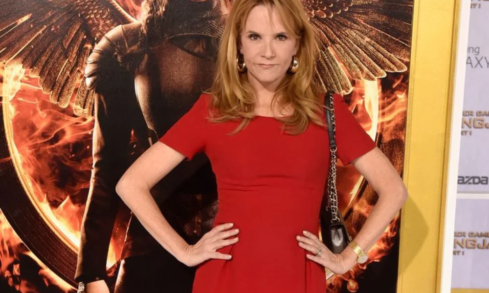 Woman in a red dress poses confidently-lea thompson net worth