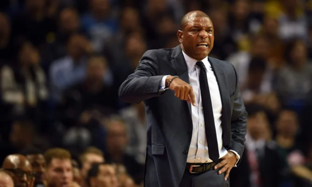  coach in a suit gestures emphatically on the sidelines during a game