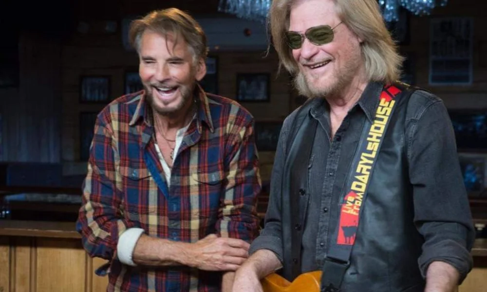 Two men smiling warmly in a cozy-daryl hall net worth
