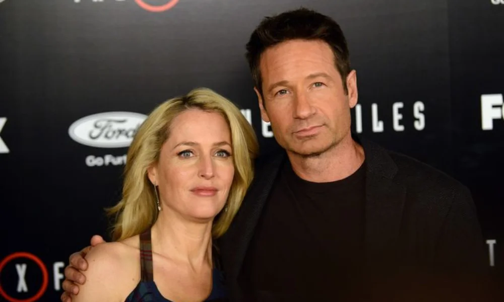 A man and woman pose closely at a formal event,
