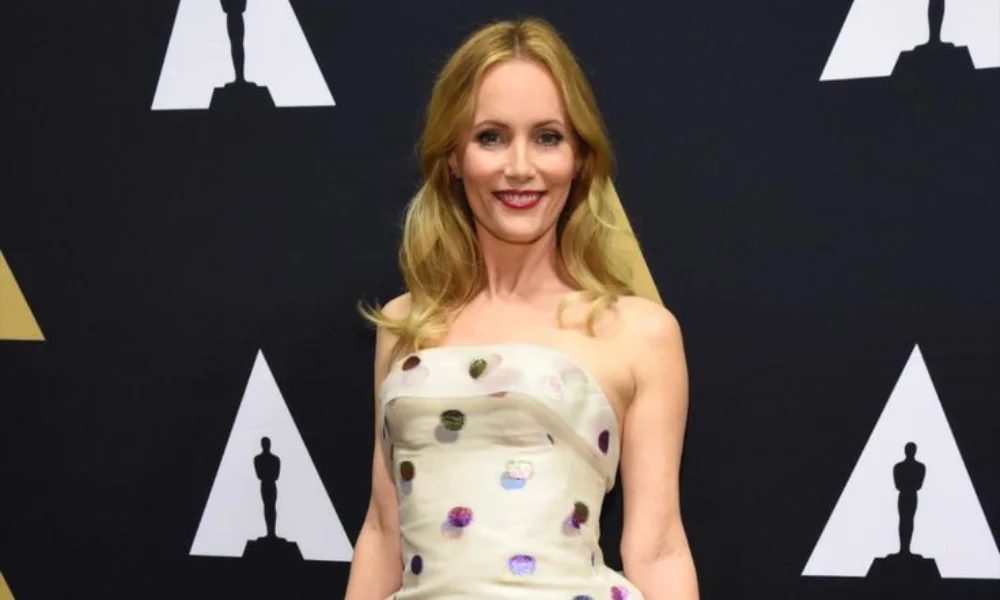 A woman in a strapless, polka-dot dress smiles on a red carpet -leslie mann net worth