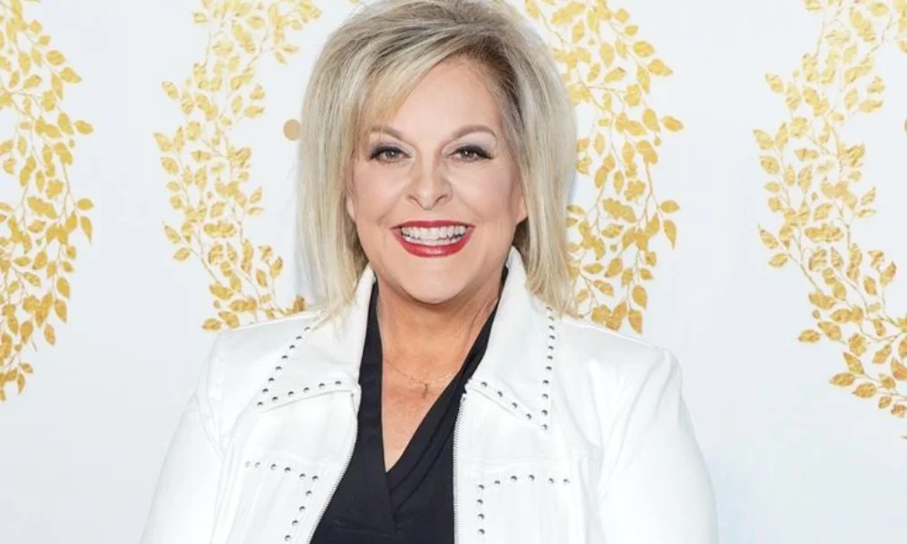 Smiling woman in a white jacket and black top