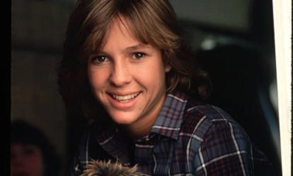 Smiling person with short, light brown hair