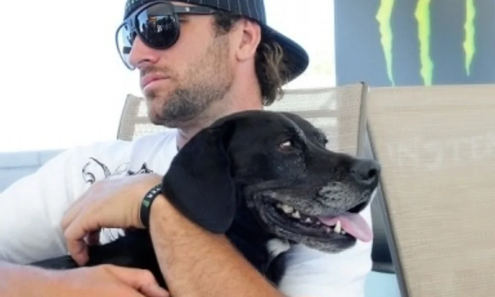 A man wearing sunglasses and a cap sits confidently