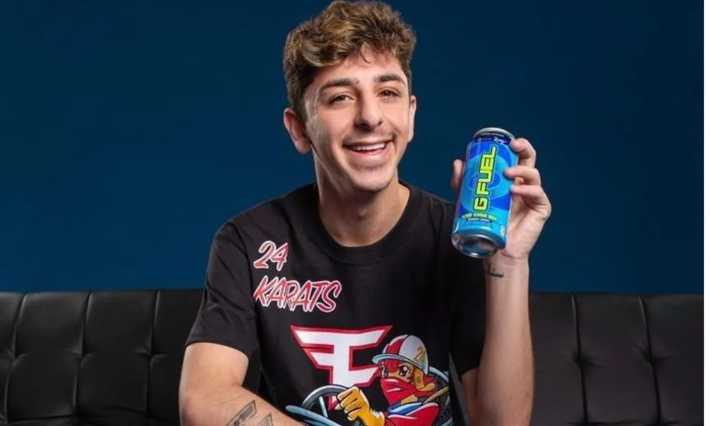 A person smiles while holding a can of G Fuel-net worth of faze rug