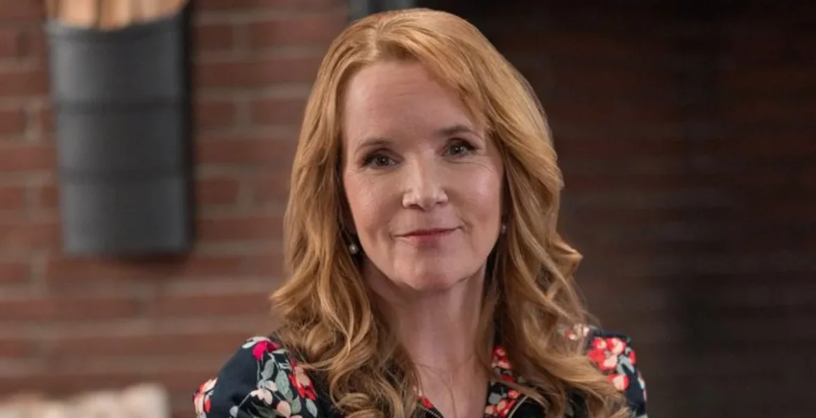 Woman with long, wavy auburn hair smiles softly