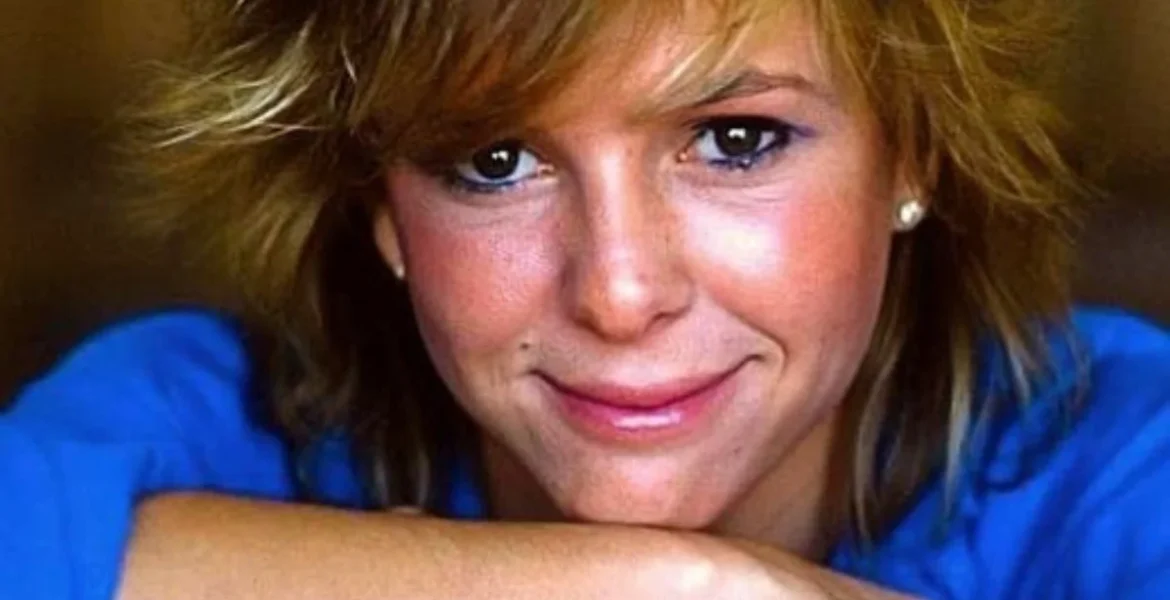 Young woman with short, tousled hair and a warm smile