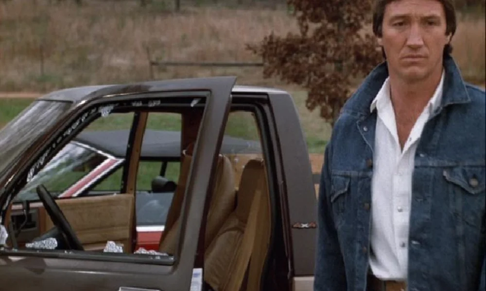 A man in a denim jacket stands next to a car-alan autry net worth