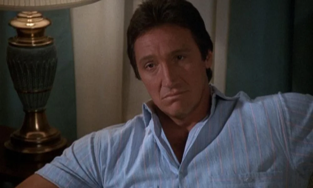 Man in a blue striped shirt sits on a couch-alan autry net worth