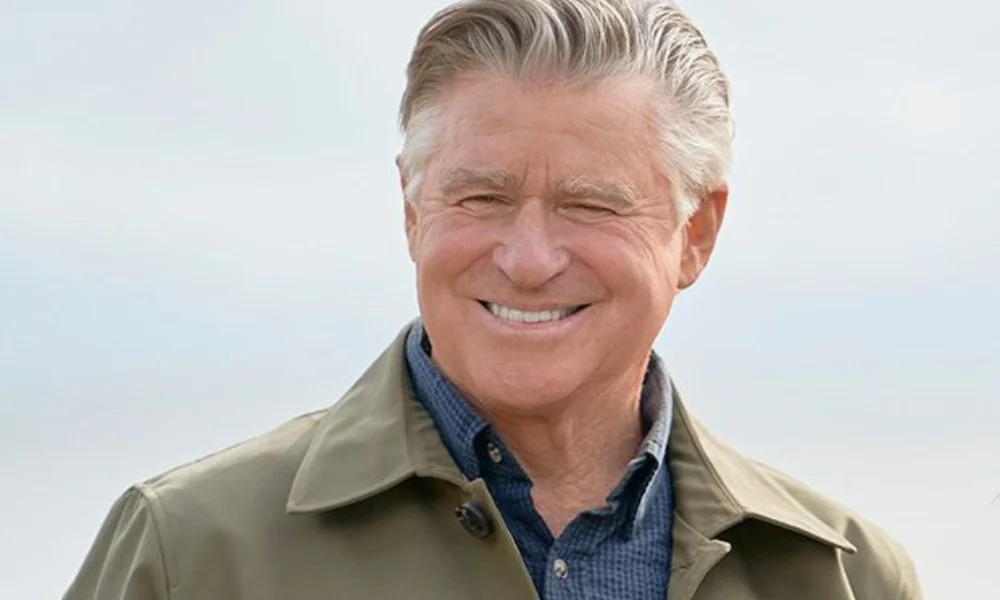 Smiling older man with gray hair in a tan jacket
