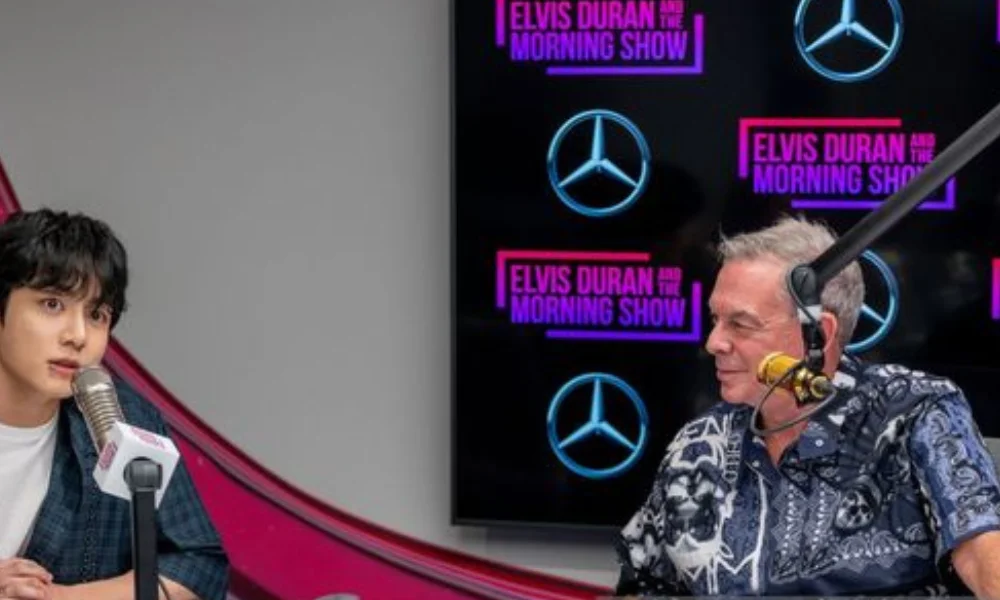 Two men are seated at a radio station studio