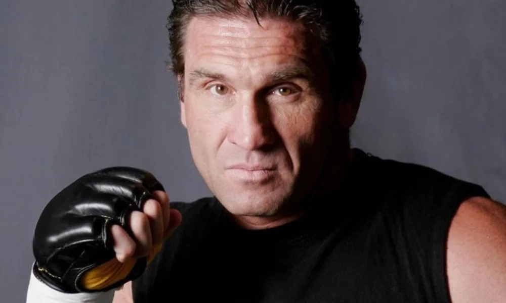Man wearing a sleeveless black shirt and black fingerless gloves-ken shamrock net worth