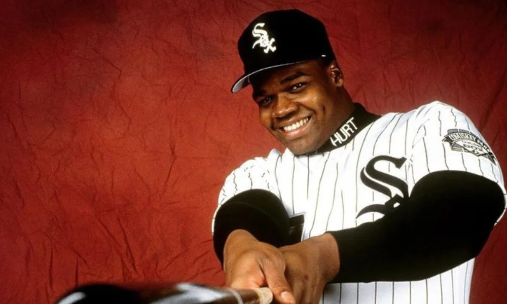 A smiling baseball player in a white pinstripe jersey-frank thomas net worth