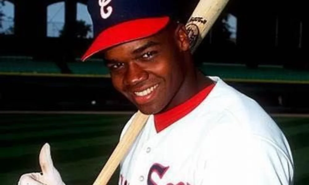 Smiling baseball player in a white jersey and red cap