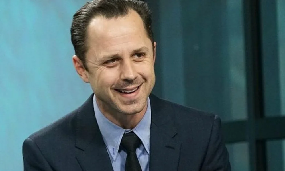 Smiling man in a dark suit and tie-giovanni ribisi net worth