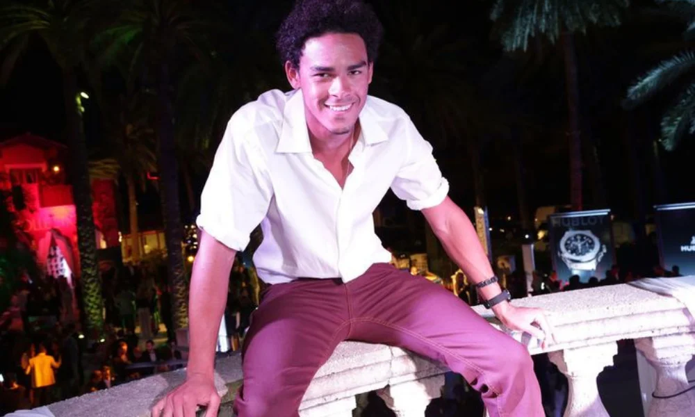 Smiling man in a white shirt and red pants