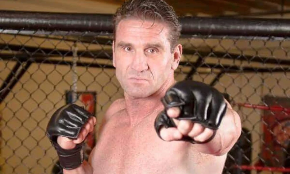 A man in a fighting stance inside a cage