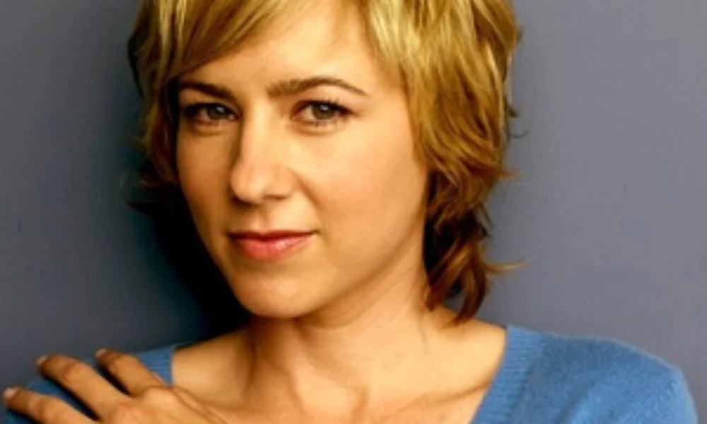 A person with short, wavy blond hair