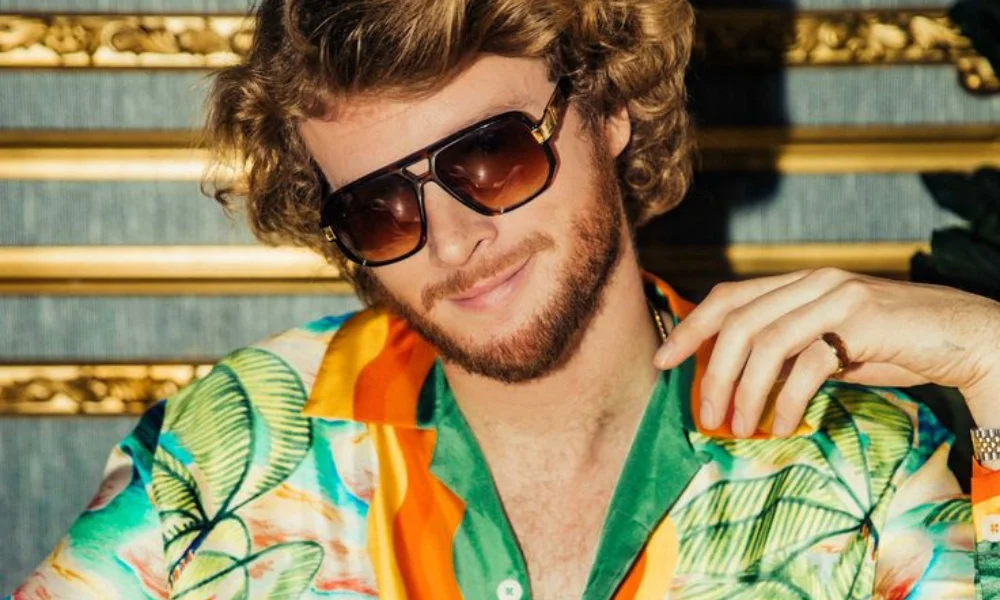 A man with curly hair and a beard smiles-yung gravy net worth