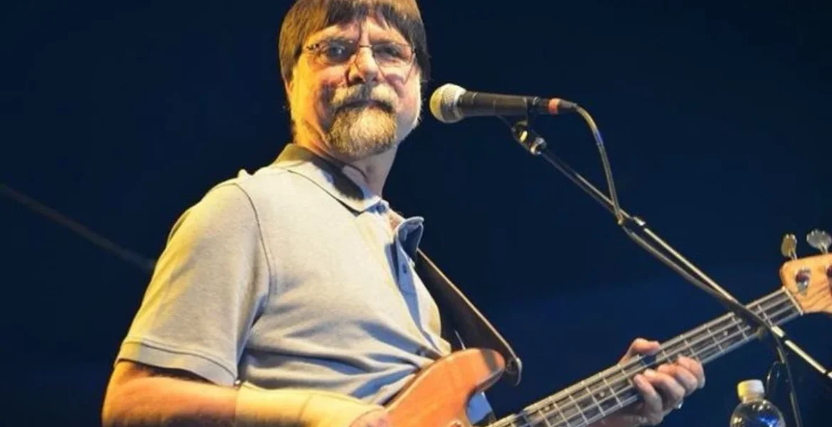 A man with glasses plays a bass guitar