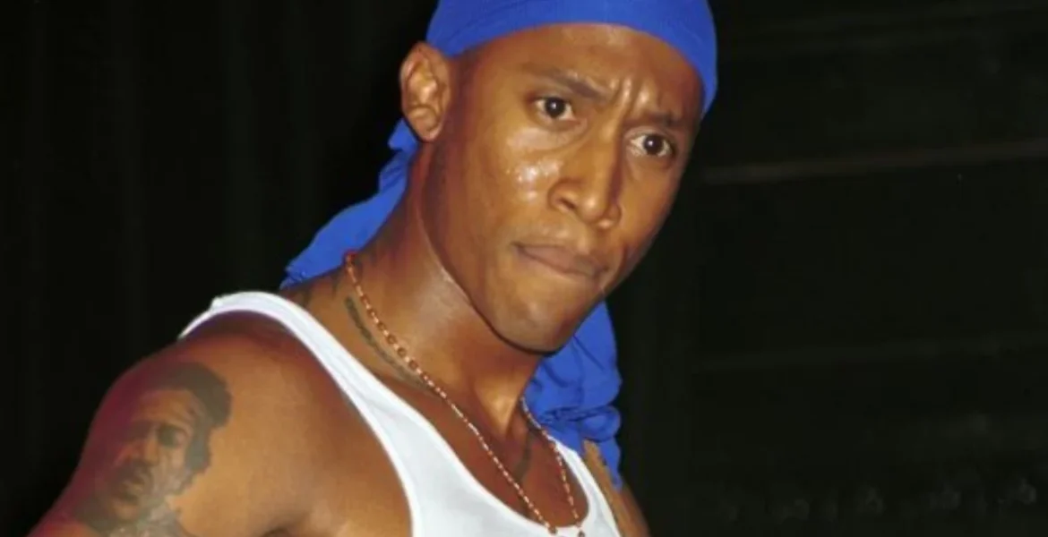 Man in a blue durag and white tank top