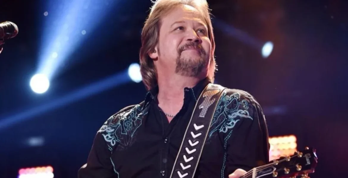 Man with a beard on stage playing a guitar