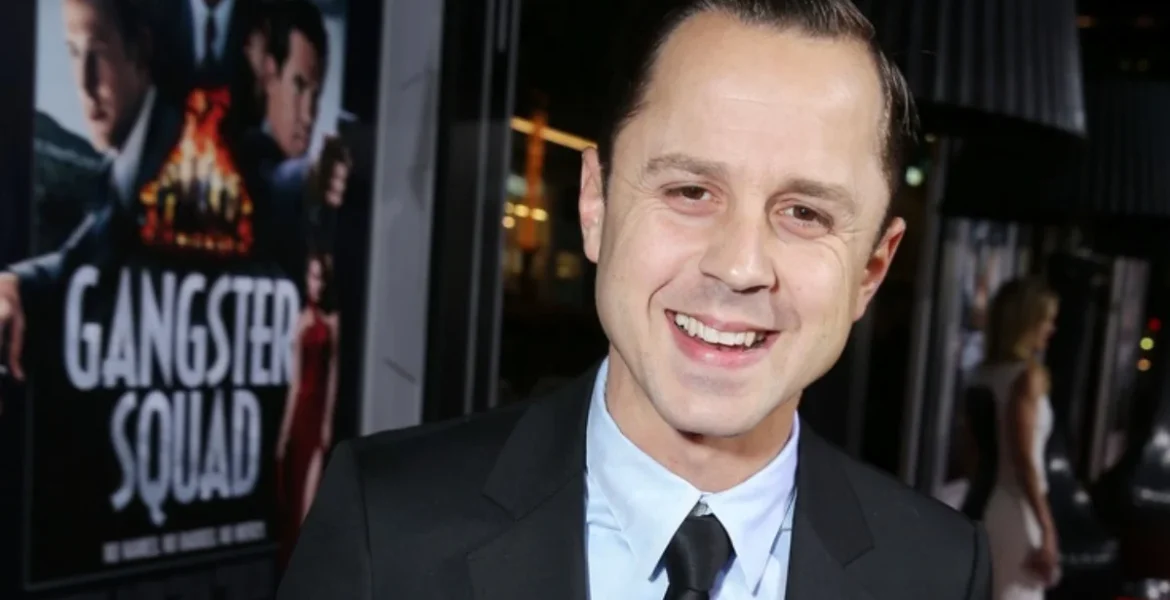 A man in a suit smiles widely at an event