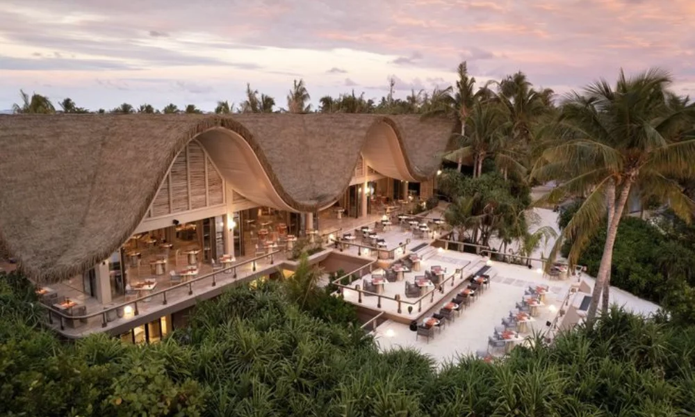 A tropical resort with wavy thatched roofs